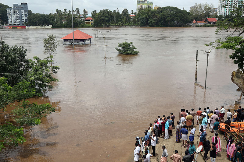 FILE PHOTO: People stand on the steps of Aluva Shiva Temple complex submerged in water after the opening of Idamalayar dam gate following heavy rains, on the outskirts of Kochi, India, August 9, 2018. Photo: Reuters