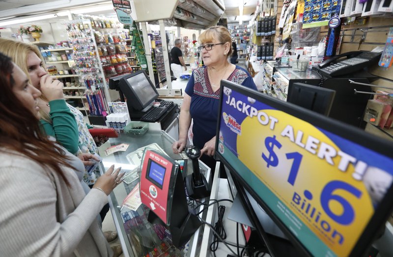 FILE: Daysi Lorenzo, center, sells lottery tickets, on Monday, Oct. 22, 2018, at La Preferida Superdiscount store in Hialeah, Florida. Photo: AP
