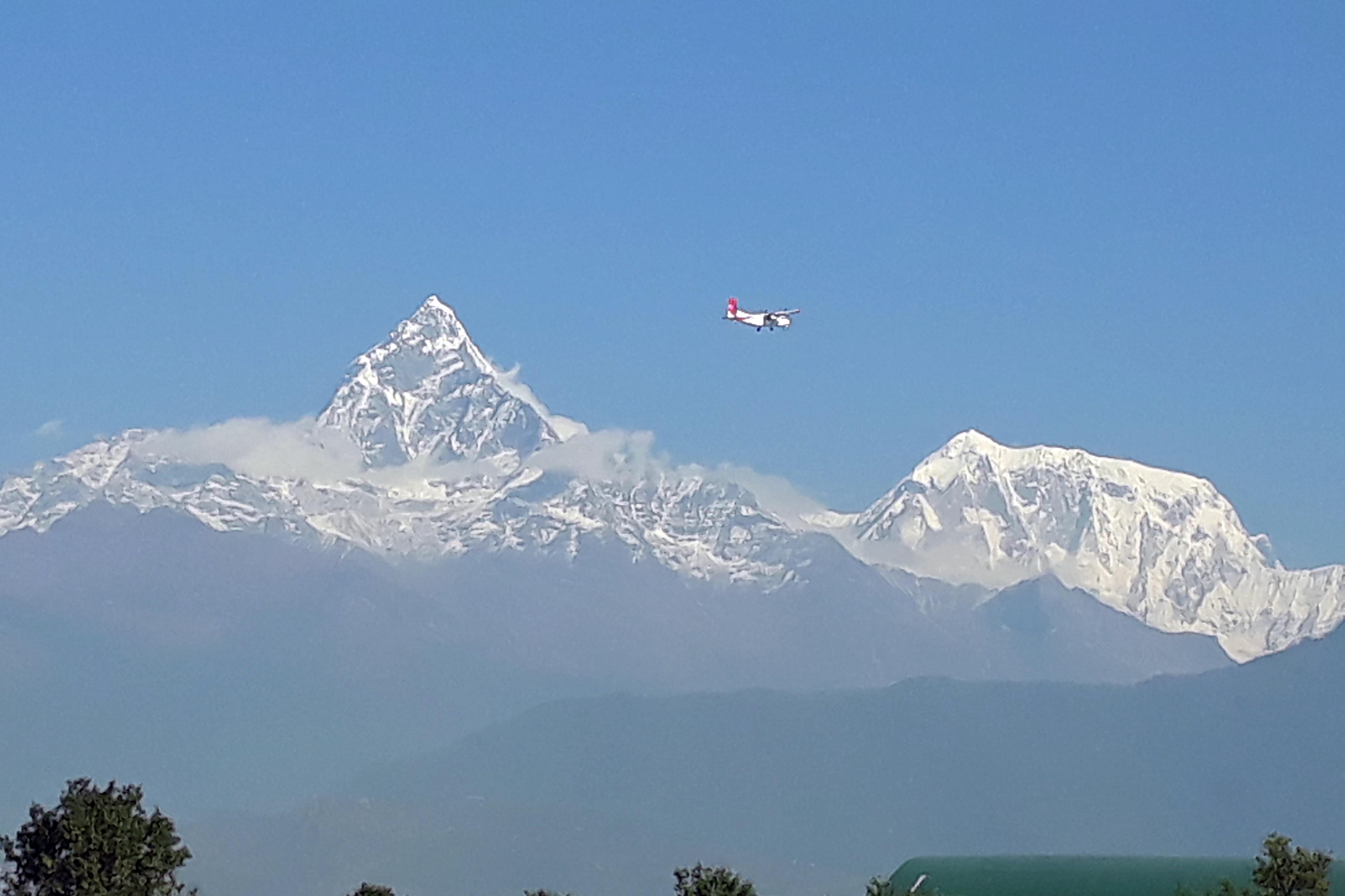 An aircraft flies by Machhapuchare (Fishtail) Mountain and other peaks in Annapurna and Dhaulagiri mountain range as seen from Pokhara on Friday, October 26, 2018. Photo: Rishi Ram Baral/ THT