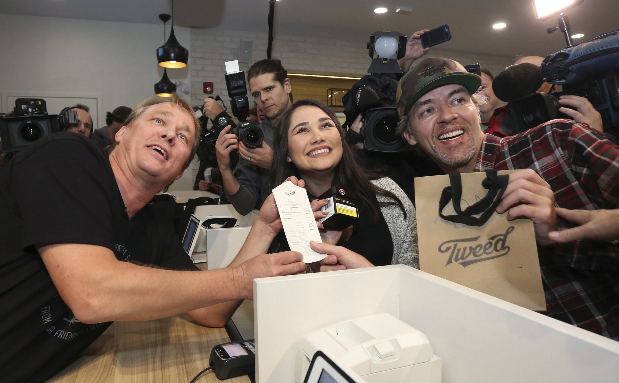 Canopy Growth CEO Bruce Linton, left to right, poses with the receipt for the first legal cannabis for recreation use sold in Canada to Nikki Rose and Ian Power at the Tweed shop on Water Street in St. John's N.L. at 12:01 am NDT on Wednesday Oct. 17, 2018. 