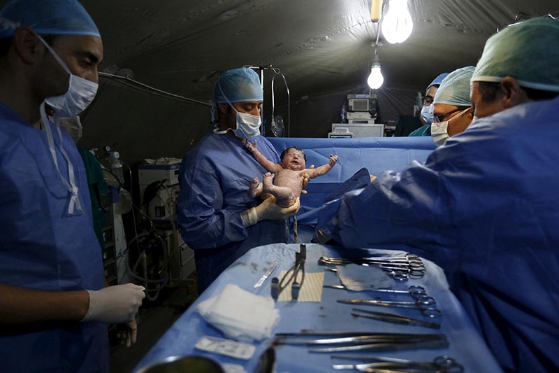 FILE PHOTO: Moroccan doctors carry a Syrian baby Siwar, who was born by caesarean section in a field hospital in Al Zaatari refugee camp in the Jordanian city of Mafraq, near the border with Syria, March 7, 2016. Photo: Reuters