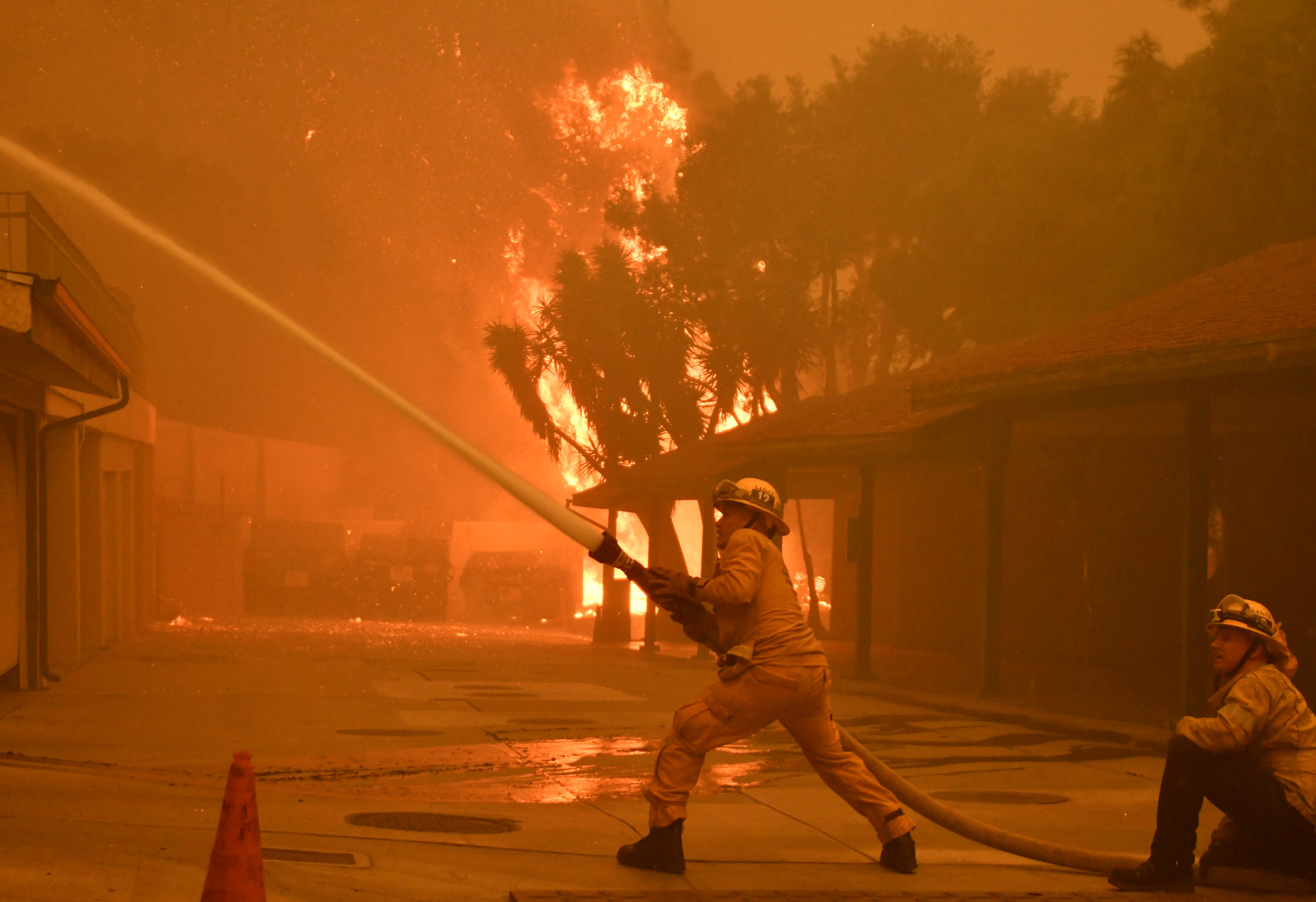 Firefighters hose down a condo unit during the Woolsey Fire in Malibu, California, U.S. November 9, 2018.  REUTERS/Gene Blevins