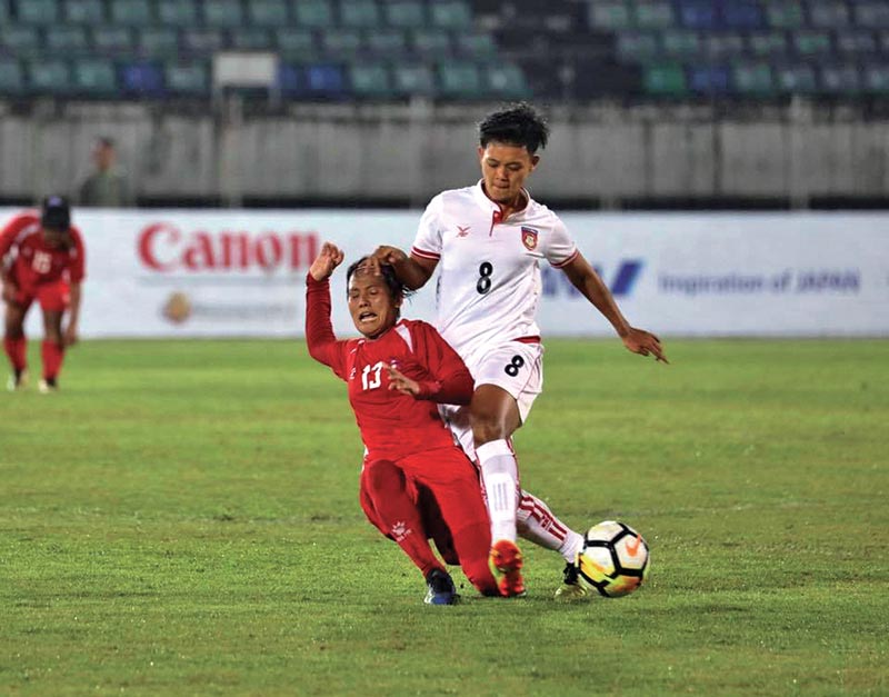 Nepal’s Dipa Rai (left) and Myanmar’s July Kyaw vie for the ball during their AFC Women’s Olympic Qualifying Tournament match at the Thuwunna Football Stadium in Yangon on Sunday. Photo Courtesy: Myanmar Football Federation