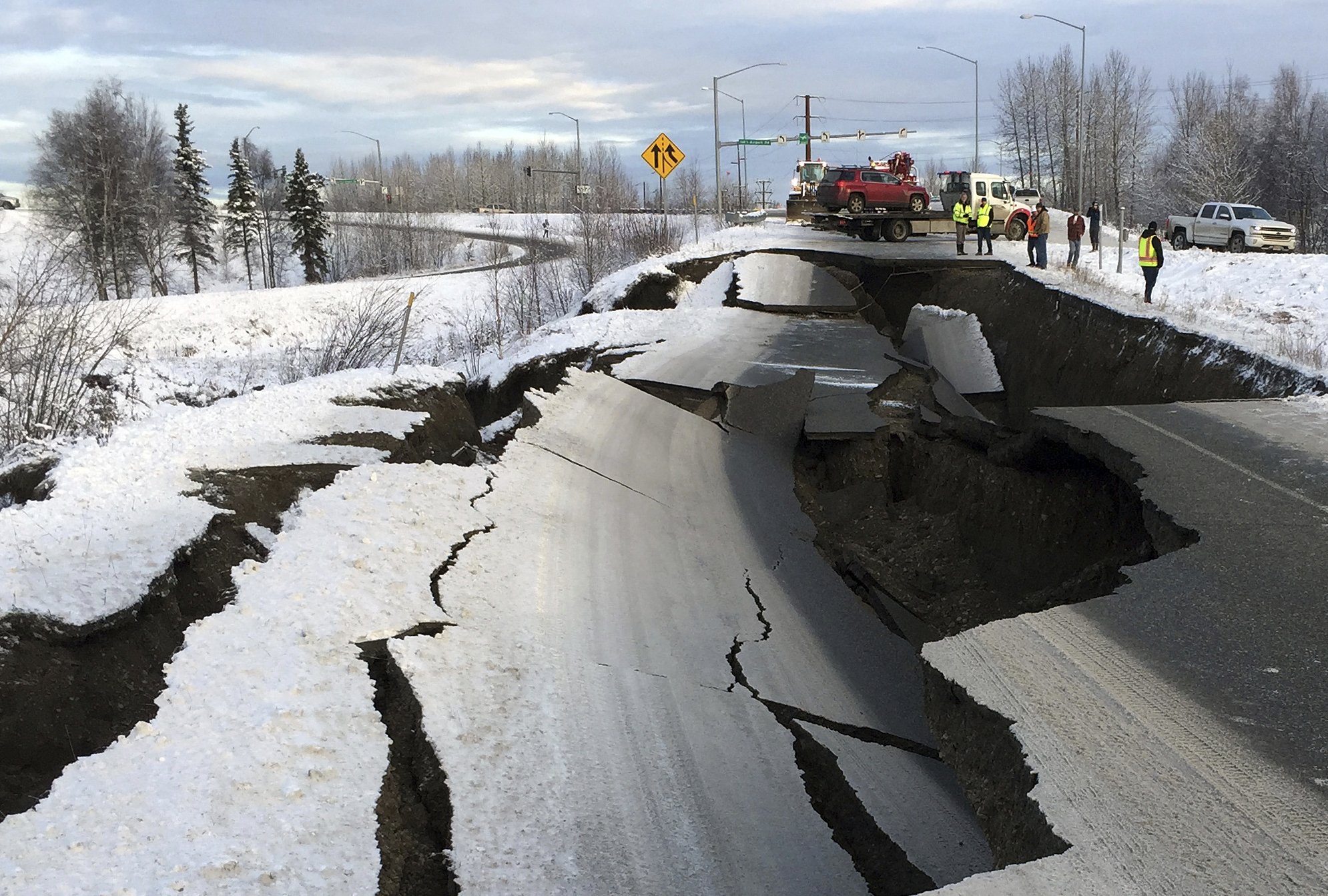 A tow truck holds a car that was pulled from on an off-ramp that collapsed during a morning earthquake on Friday, Nov. 30, 2018, in Anchorage, Alaska. Photo: AP