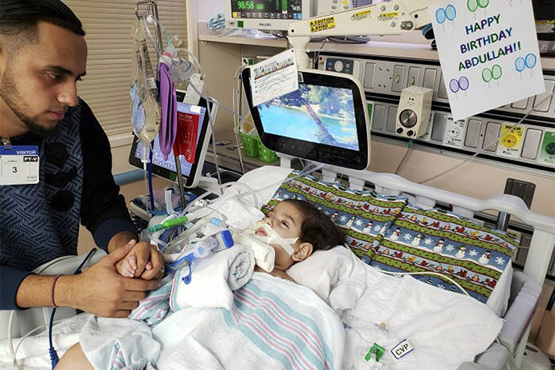 File: Ali Hassan with his dying 2-year old son Abdullah in a Sacramento hospital. Courtesy: AP