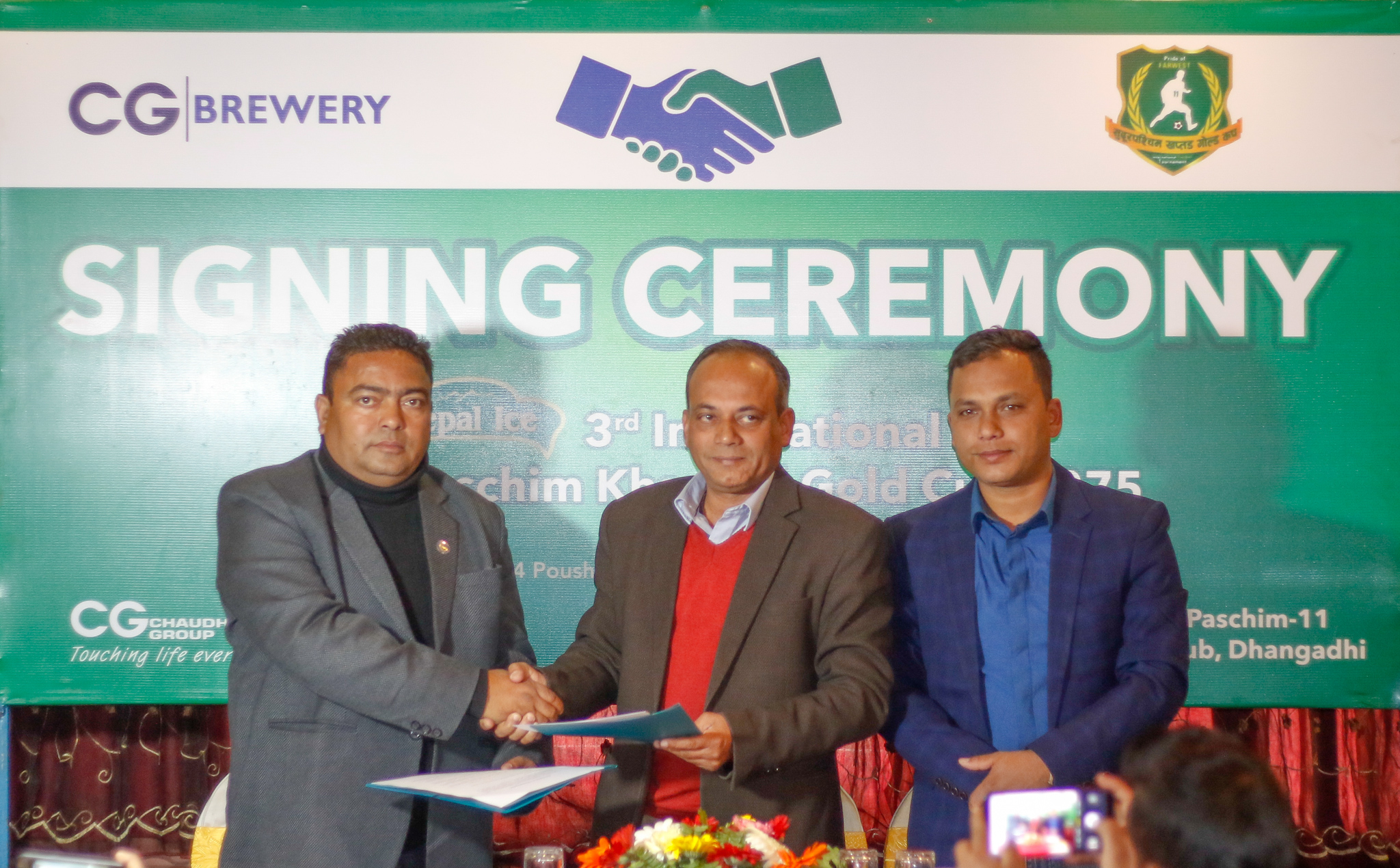Farwest Sporting Club President Suresh Hamal and Senior General Manager of CG Brewery Pradeep Pudasaini exchange MoU as FSW General Secretary Prakash Shahi looks on during a press meet in Kathmandu on Saturday, December 29, 2018. Photo: THT
