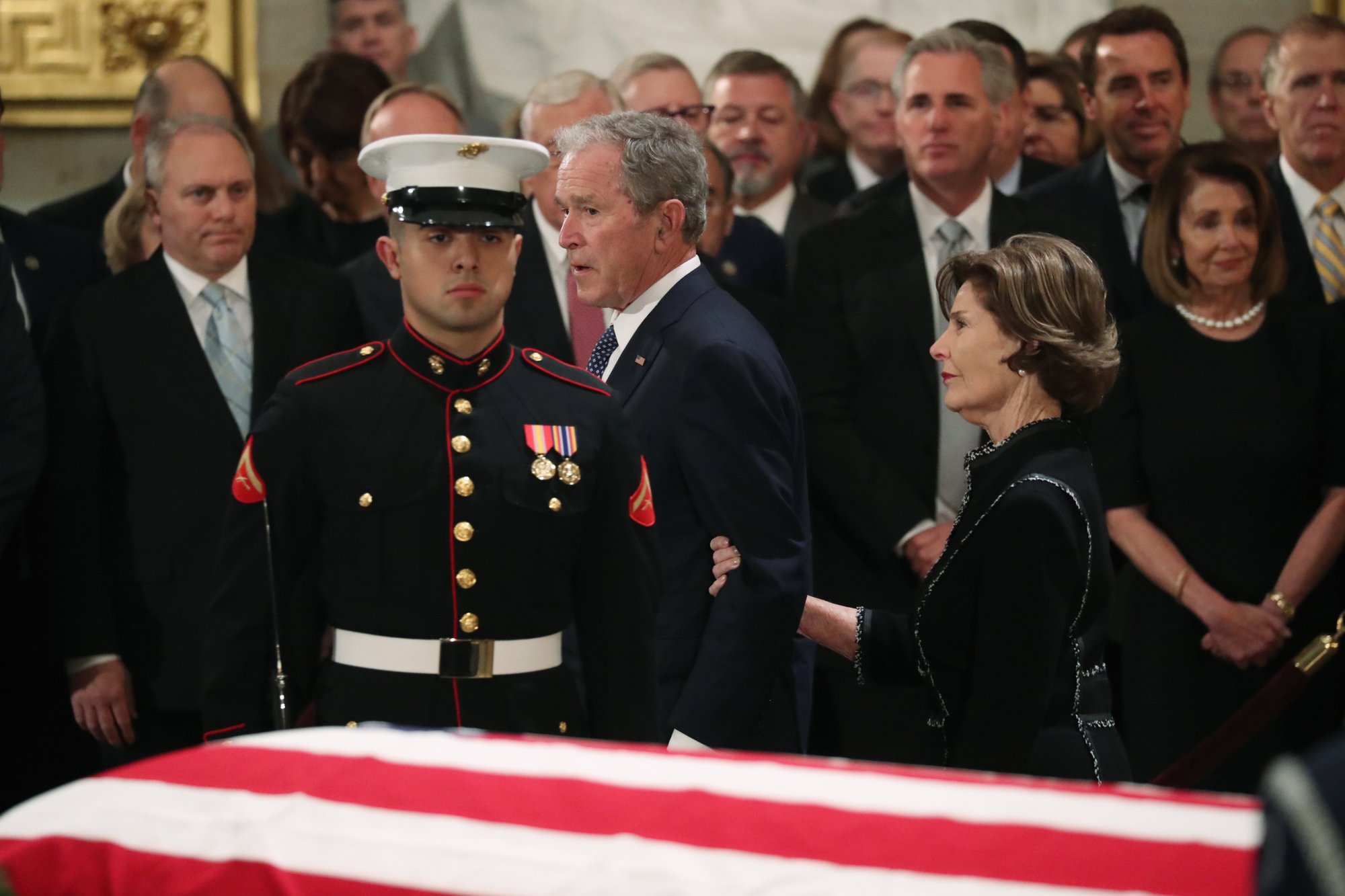 Former President George W. Bush, with his wife former first lady Laura, walks past the casket of his father, former President George H.W. Bush at the Capitol in Washington, on Monday, Dec. 3, 2018. Photo: AP
