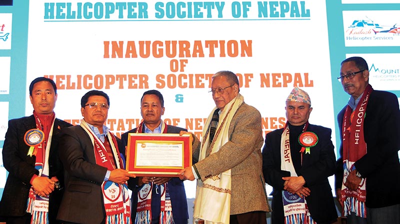 Minister of Culture, Tourism and Civil Aviation Rabindra Adhikari handing over a certificate of commendation to Rabindra Prasad Pradhan, the first helicopter pilot of Nepal, in Kathmandu, on Tuesday. Photo: THT
