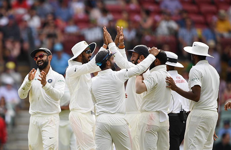 India's captain Virat Kohli (L) reacts with teammates after the dismissal of Australia's Peter Handscomb on day four of the first test match between Australia and India at the Adelaide Oval in Adelaide, Australia, December 9, 2018. Photo: AAP/Dave Hunt/via Reuters