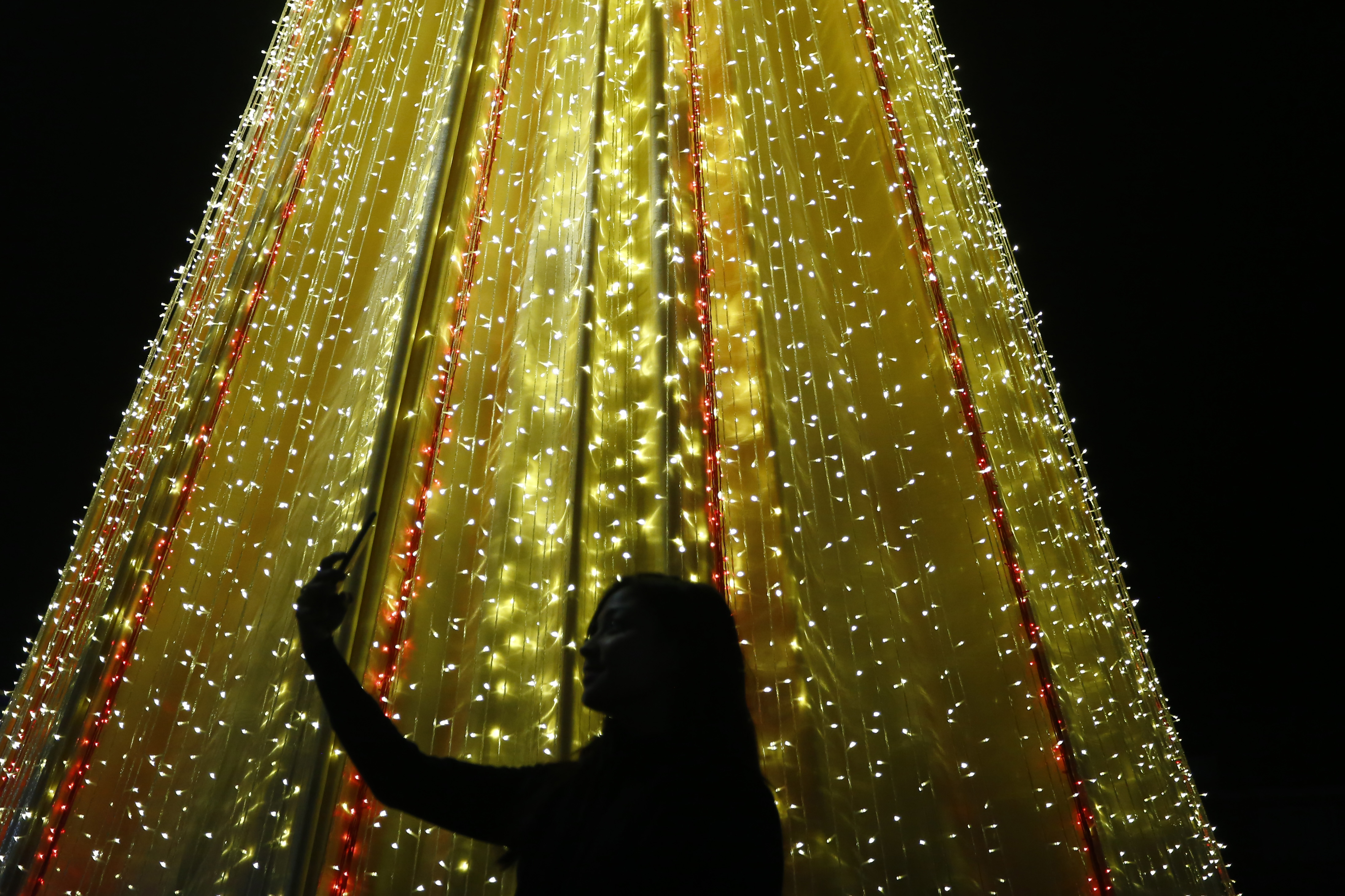 A girl clicks a selfie in front of a structure decorated in Christmas lights in preparations of upcoming Christmas festival at Labim mall in Lalitpur, Nepal on Friday, December 14, 2018. Photo; Skanda Gautam/THT
