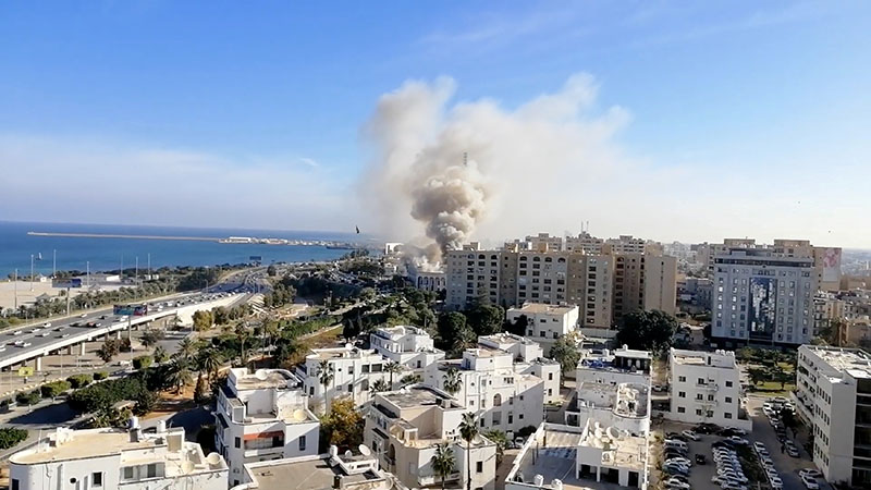Smoke rises from the Libyan foreign ministry building in Tripoli, Libya December 25, 2018, in this still image obtained from a social media video. Youtube/Mohammed Elgotani via Reuters