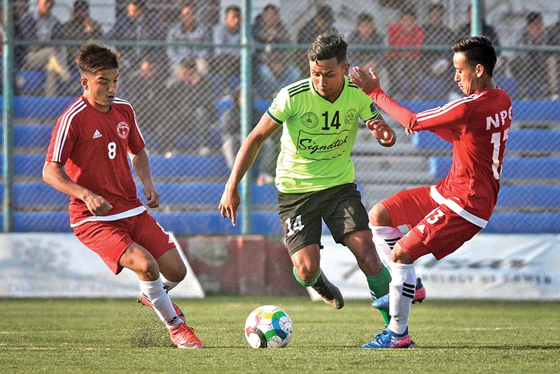 Anjan Bista (centre) of MMC vies for the ball with NPC players during their Pulsar Martyrs Memorial A Division League match in Lalitpur on Sunday. Photo: Naresh Shrestha/ THT