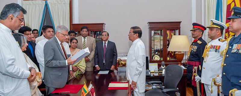 Ranil Wickremesinghe, ousted prime minister in October, takes his oath for the same post before Sri Lanka's President Maithripala Sirisena during his swearing-in ceremony in Colombo, Sri Lanka December 16, 2018. Photo: President Media Division/Handout via Reuters