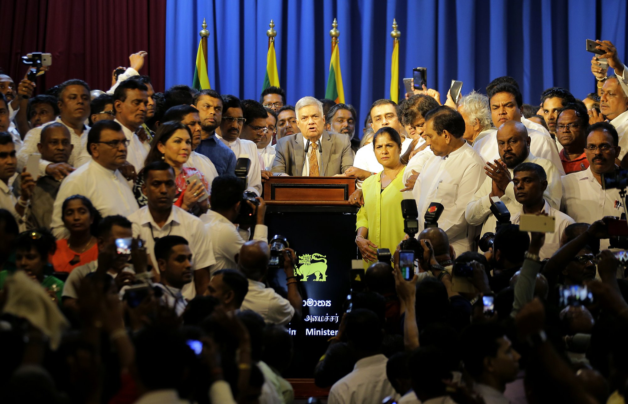 Sri Lanka's reinstated Prime Minister Ranil Wickeremesinghe, center, surrounded by his loyal lawmakers and supporters speaks after assuming duties in Colombo, Sri Lanka, on Sunday, Dec. 16, 2018. Photo: AP