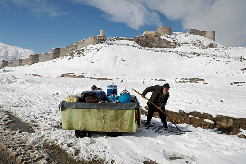 An Afghan man removes snow next to his handcart after the first snow in winter on the snow-covered ground in Kabul, Afghanistan, January 5, 2019. Photo: Reuters