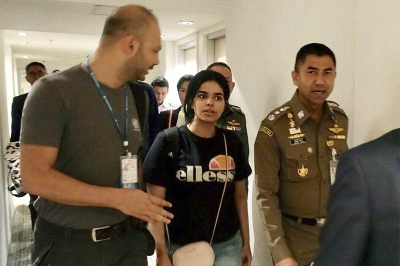 Chief of Immigration Police Maj. Gen. Surachate Hakparn (right) walks with Saudi woman Rahaf Mohammed Alqunun before leaving the Suvarnabhumi Airport in Bangkok. Photo: AP