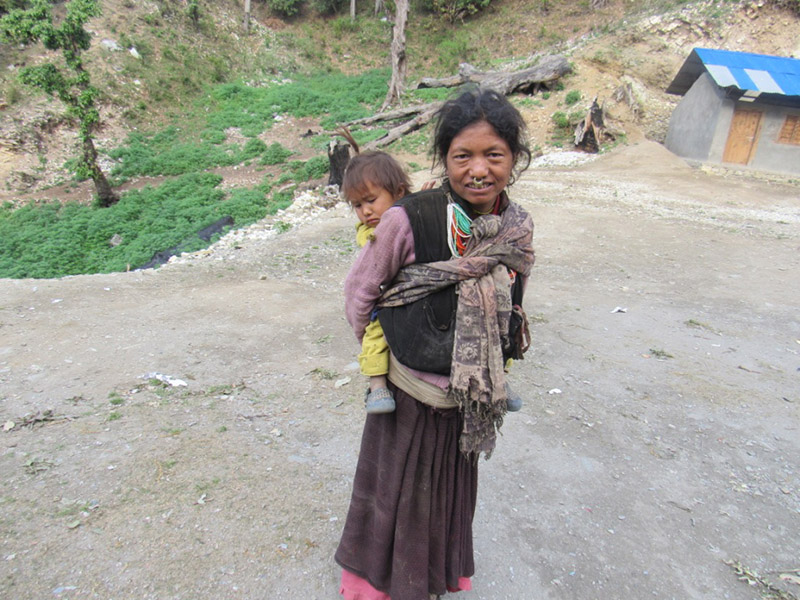 Kalasari Budha (43) carrying her youngest child, in Kot, of Himali Rural Municipality-1, in  Bajura district, on Tuesday, February 26, 2019. Budha gave birth to 12 children by the time time she was 40. Photo: Prakash Singh/THT