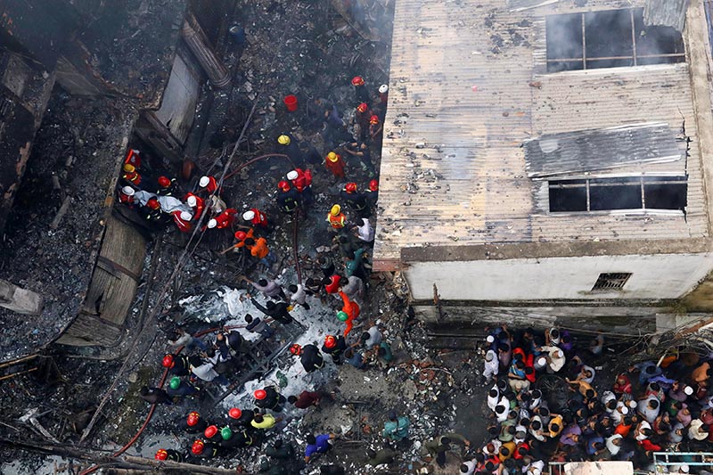 A dead body is carried out from a burnt warehouse in Dhaka, Bangladesh, on Thursday, February 21, 2019. Photo: Reuters