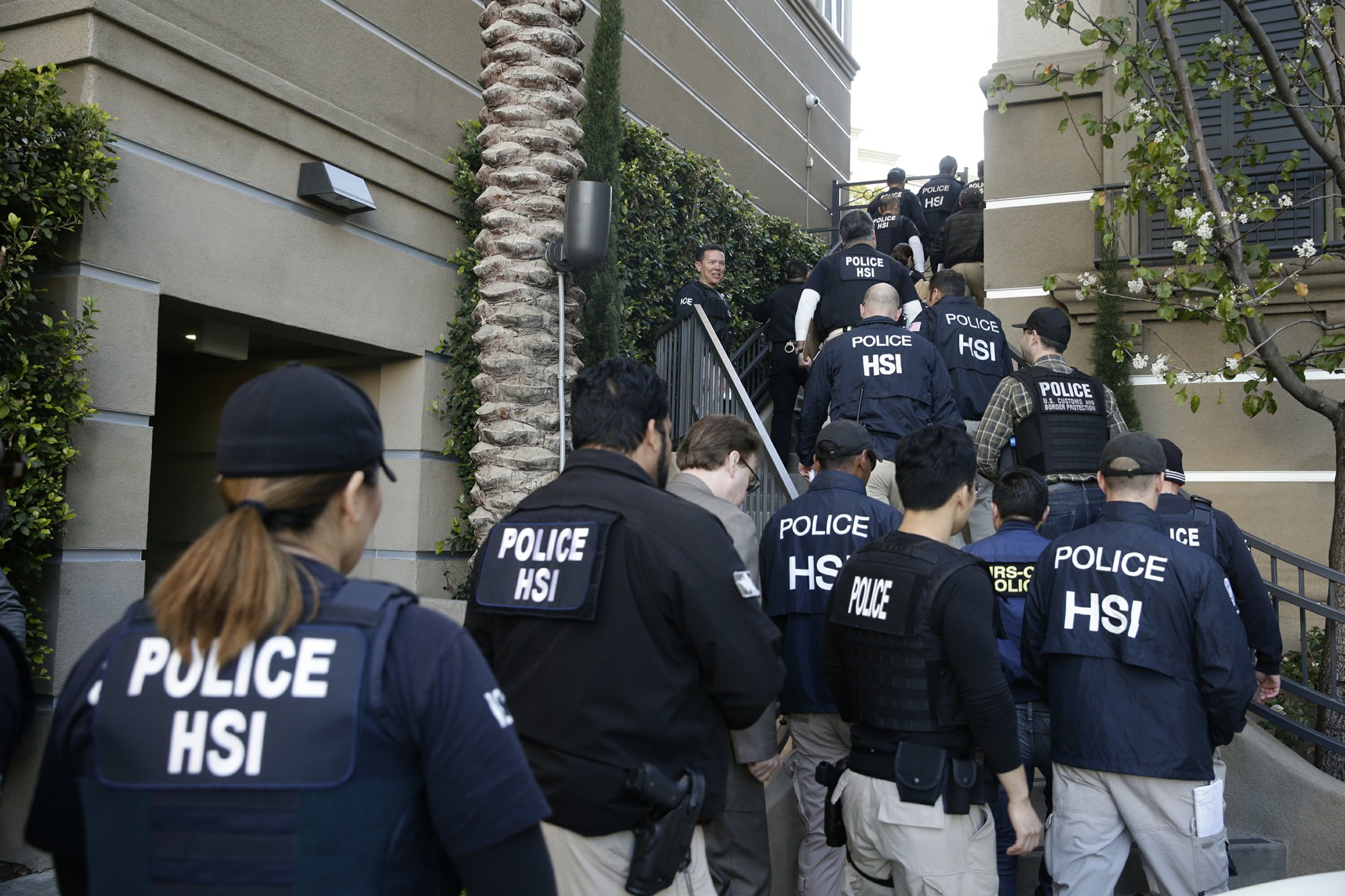 FILE - In this March 3, 2015 file photo, federal agents enter an upscale apartment complex where authorities say a birth tourism business charged pregnant women $50,000 for lodging, food and transportation, in Irvine, California. Photo: AP