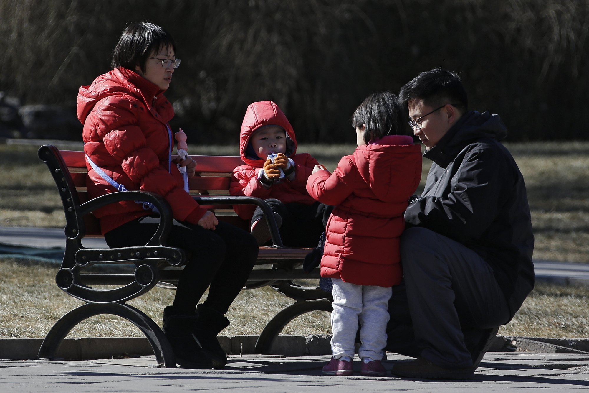 In this Feb. 17, 2019, photo, a couple spend time with their children at a park in Beijing. Photo: AP