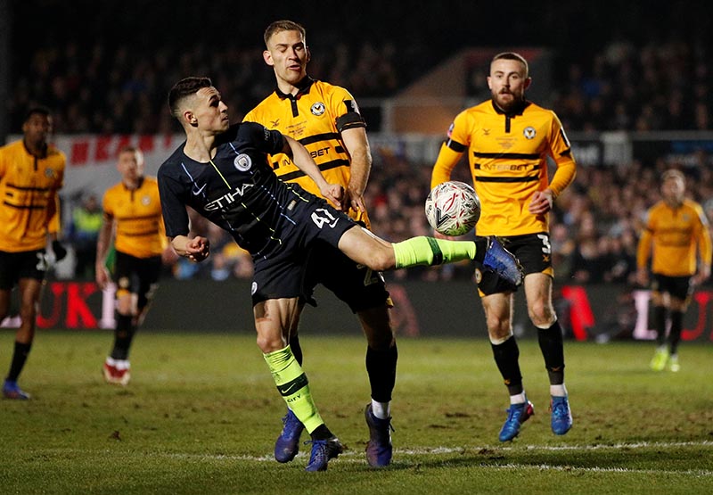 Manchester City's Phil Foden in action with Newport's Mickey Demetriou during the FA Cup Fifth Round match between Newport County AFC and Manchester City, at Rodney Parade, in Newport, Britain, on February 16, 2019. Photo: Action Images via Reuters