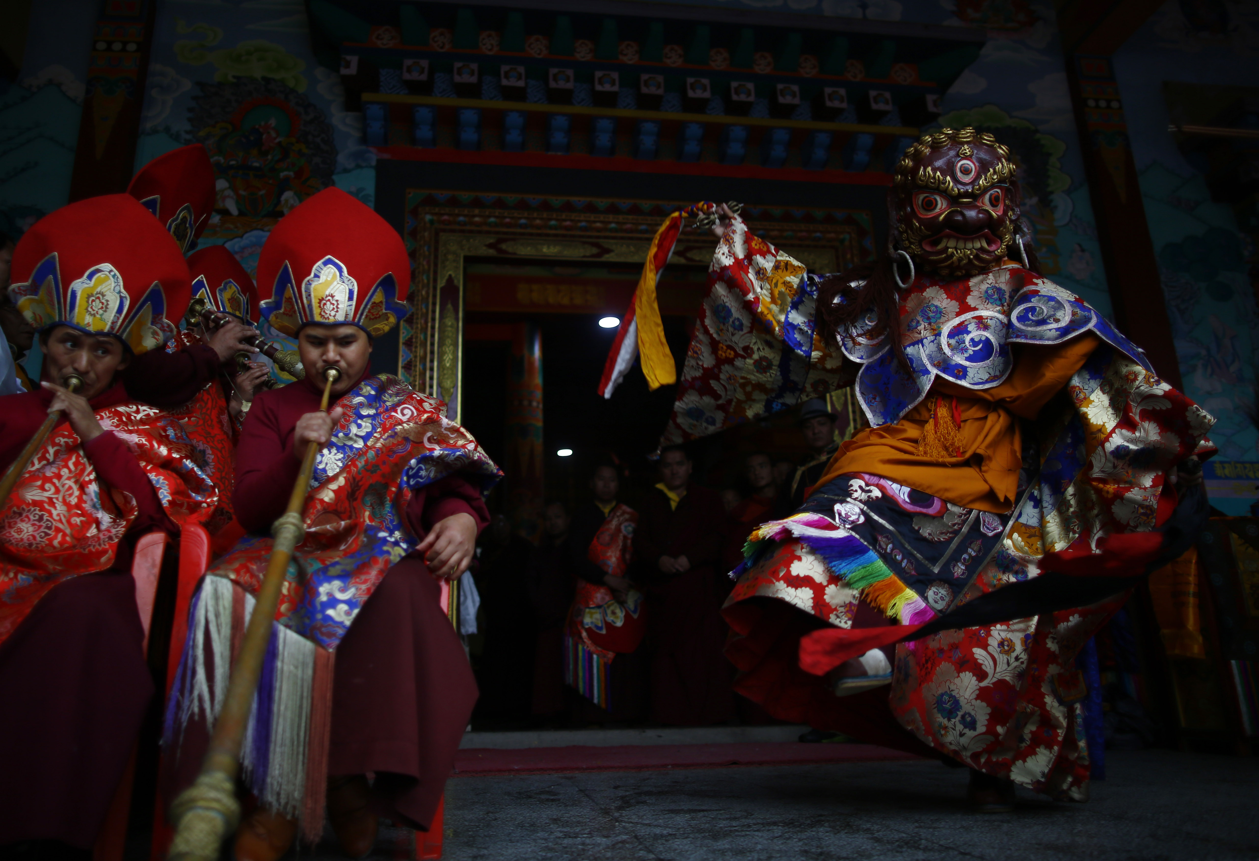 FILE - Buddhist monks play traditional musical instrument while a masked dancer performs during Gyalpo Lhosar, at the Sherpa Monastery, in Kathmandu. Photo: Skanda Gautam/THT