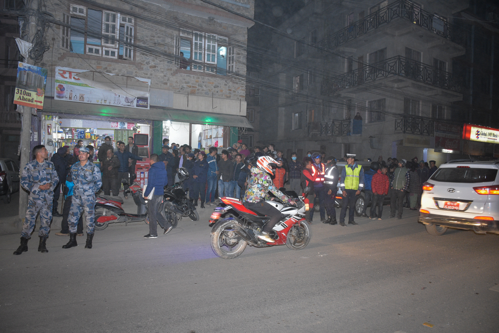 Panic-stricken crowd and eyewitnesses of the explosion gather at a pavement near the incident site while police personnel take stock of the damage, in Nakkhu, Lalitpur, on Friday, February 22, 2019. Photo: Naresh Shrestha/THT