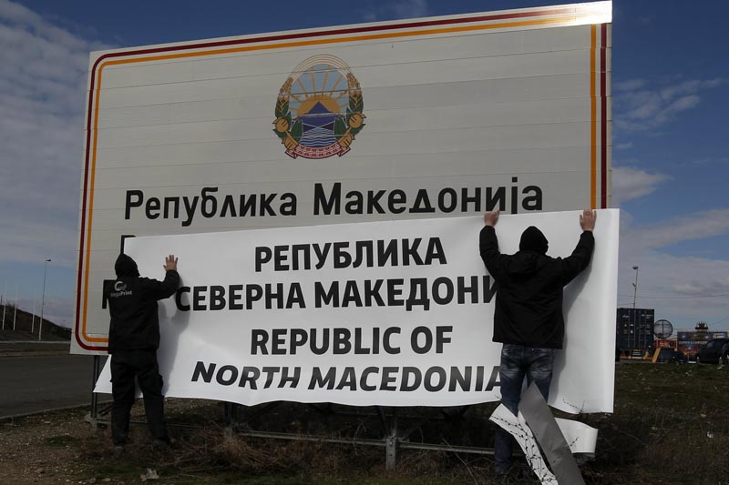 Workers replace signage with an adhesive banner that reads Republic of North Macedonia in the southern border with Greece, near Gevgelija, Wednesday, Feb. 13, 2019. Photo: AP