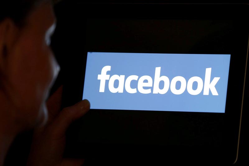 FILE PHOTO: A woman looks at the Facebook logo on an iPad in this photo illustration taken June 3, 2018.Photo: Reuters