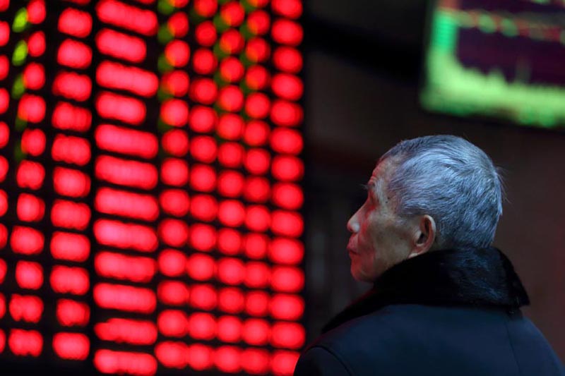 A man looks on in front of an electronic board showing stock information at a brokerage house in Nanjing, Jiangsu province, China February 13, 2019.Photo: CHINA OUT via Reuters
