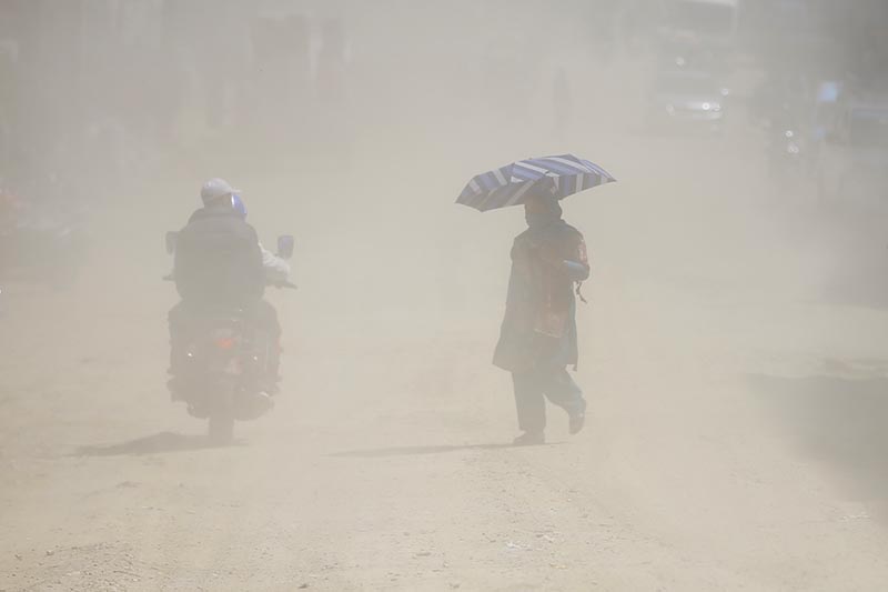 A woman crossing the dusty Chabahil-Sankhu road section in Kathmandu, on Friday, March 22, 2019. Photo: Skanda Gautam/THT