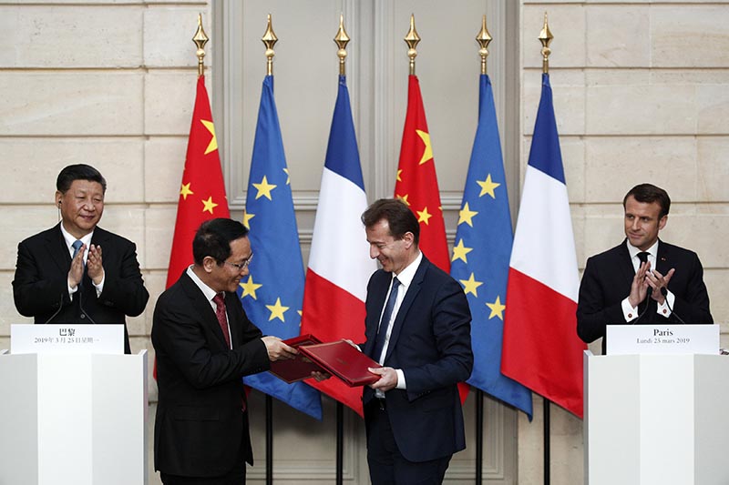 French President Emmanuel Macron and Chinese President Xi Jinping applaud as President of Airbus Commercial Aircraft, Guillaume Faury and Chairman of China Aviation Supplies Co. (CASC), Jia Baojun, shake hands during an agreement signing ceremony at the Elysee Palace in Paris, France March 25, 2019. Photo: Yoan Valat/Pool via Reuters