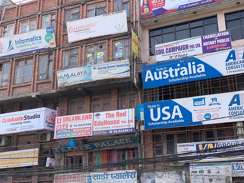 Hordes of billboards precariously perched on the walls of buildings in Putali Sadak, Kathmandu, on Wedmesday, March 27, 2019. Photo: Skanda Gautam/THT