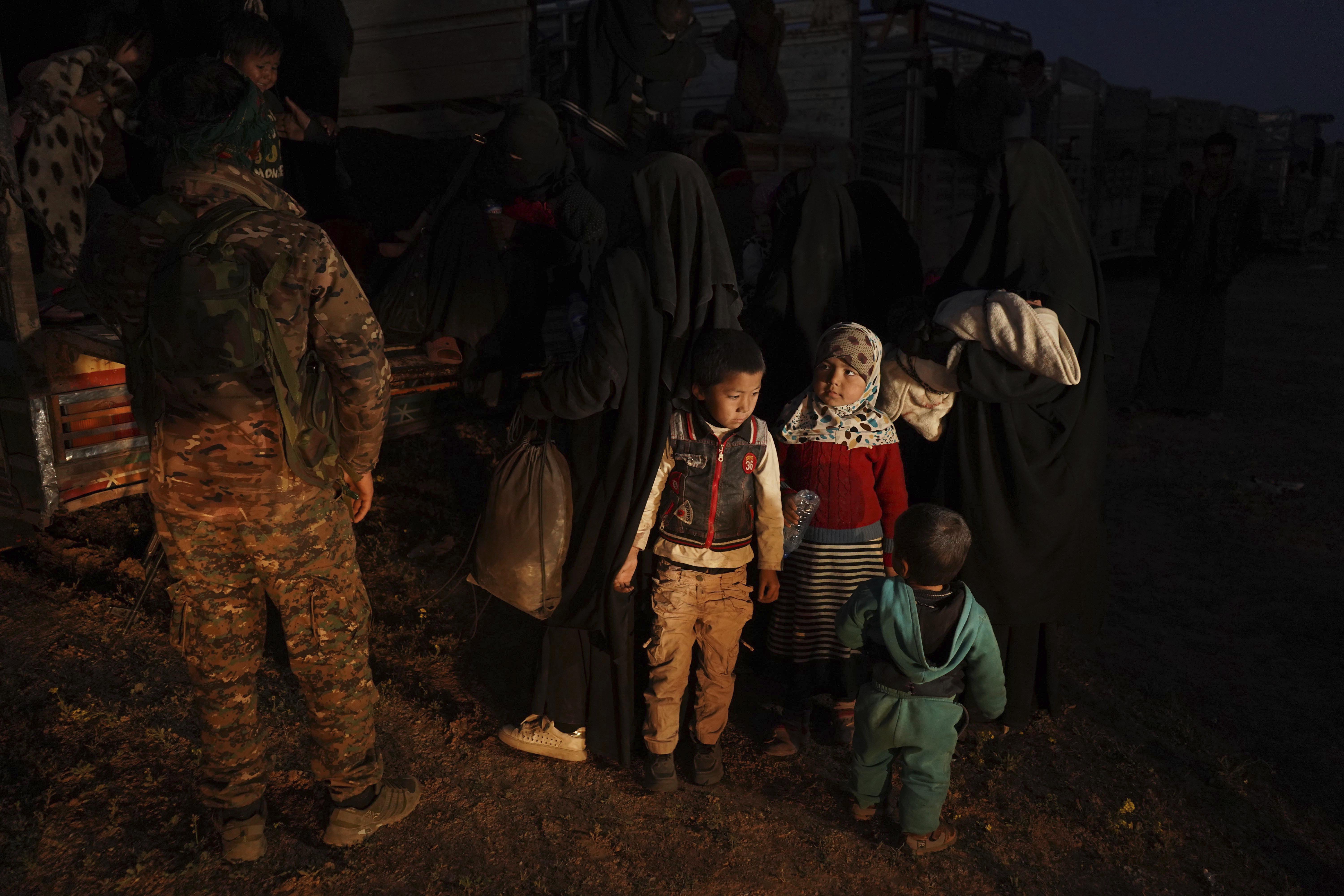 U.S.-backed Syrian Democratic Forces (SDF) move women and children into a truck after being evacuated out of the last territory held by Islamic State militants, outside Baghouz, Syria, Monday, March 4, 2019.  Photo: AP