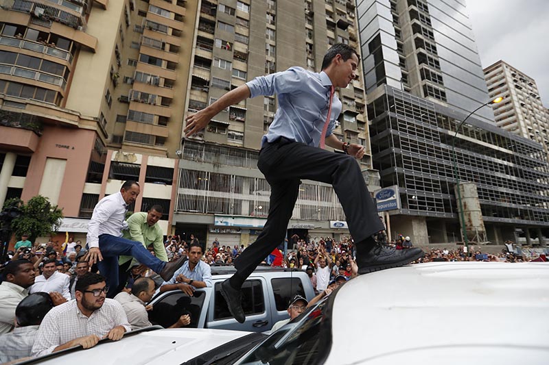 National Assembly President Juan Guaido, who declared himself interim president of Venezuela, leaps on to a vehicle to speak to supporters as he visits different points of anti-government protest in Caracas, Venezuela, Tuesday, March 12, 2019. Photo: AP