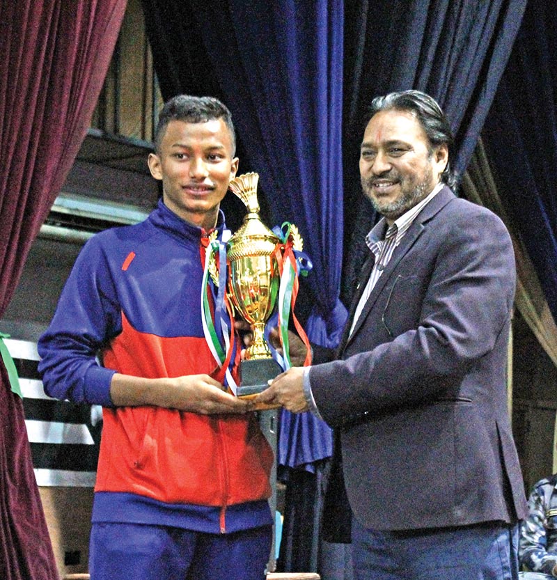 Prince Dahal of Silk Group receiving the trophy from NBA President Ramji Bahadur Shrestha (right) after winning the U-17 boysu2019 singles title of the 15th Krishna Mohan Memorial Nationwide Open in Kathmandu on Thursday.