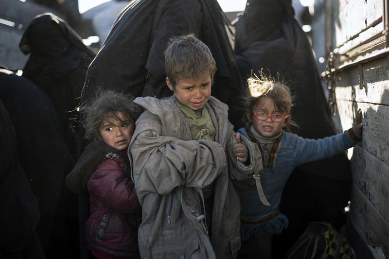 Women and children exit the back of a truck as they arrive to a US-backed Syrian Democratic Forces (SDF) screening area after being evacuated out of the last territory held by Islamic State militants, in the desert outside Baghouz, Syria, Friday, March 1, 2019.Photo: AP