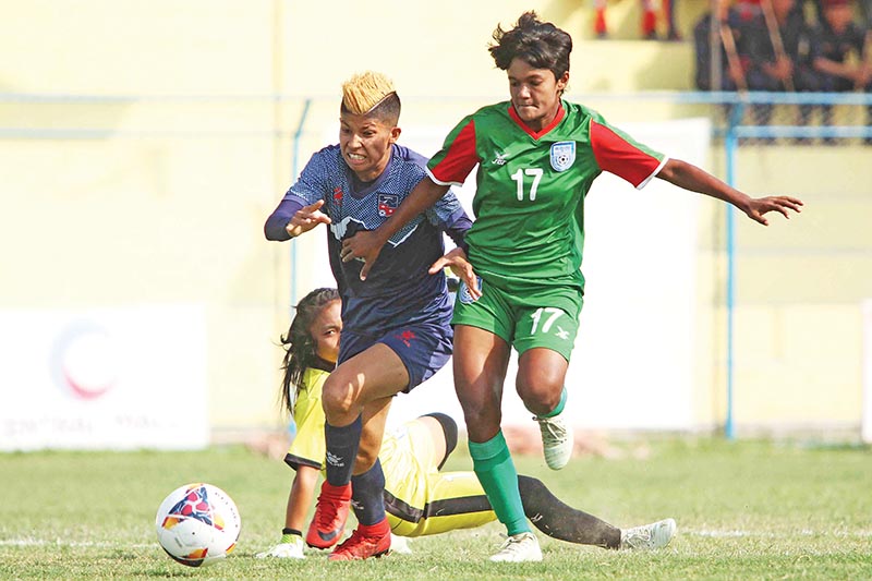 Sabitra Bhandari (left) vying for the ball against Nilufa Yesmin Nila of Bangladesh during their Women's SAFF Championship at Shahdi Rangasala in Biratnagar on Saturday. Photo: Udipt Singh Chhetry/ THT