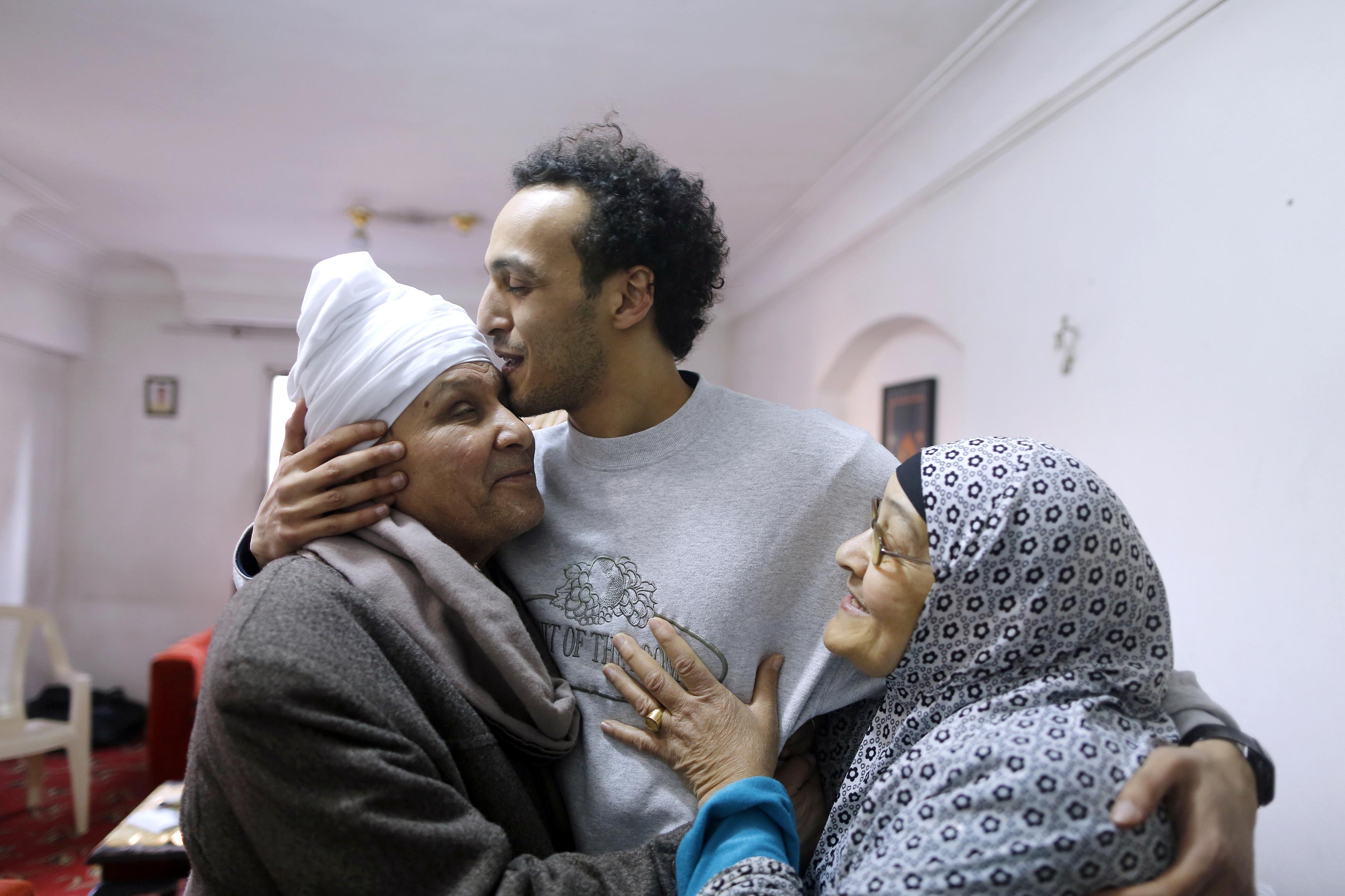 Mahmoud Abu Zaid, a photojournalist known as Shawkan, center, is hugged by his parents at his home in Cairo, Egypt, Monday, March 4, 2019. Shawkan was released after after five years in prison. Photo: AP