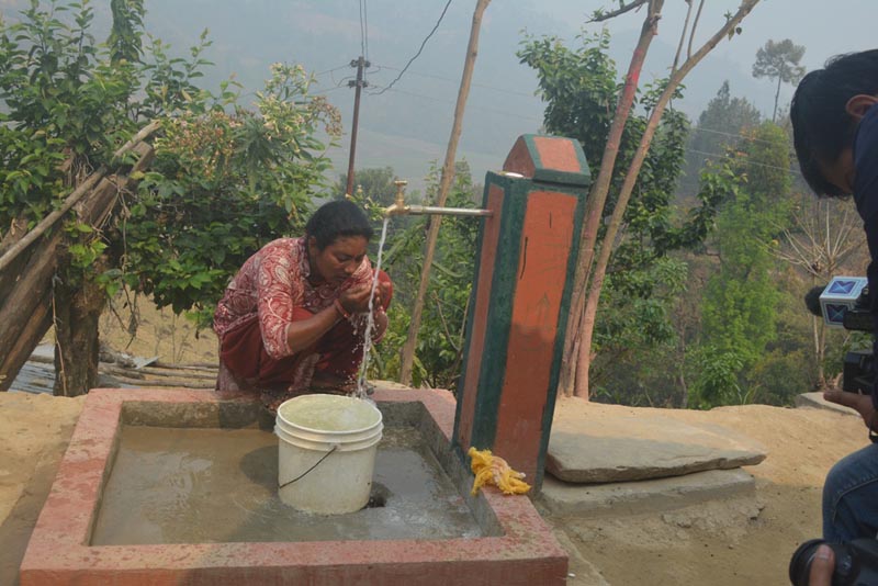 A woman drinking water from a tap in Gajuri Rural Municipality, Dhading, on Tuesday, March 26, 2019. Photo: Keshav Adhikari/THT