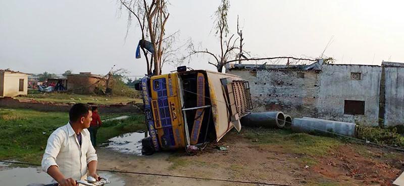A man passing by a bus overturmed on its side along the Gandak Cabal road in Bara district, on Monday, April 1, 2019. Photo: Ram Sarraf/THT