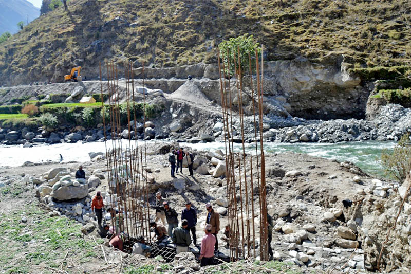 Workers erecting a pillar for belibridge over Kawadi river along Karnali Corridor. Photo: Prakash Singh/THT