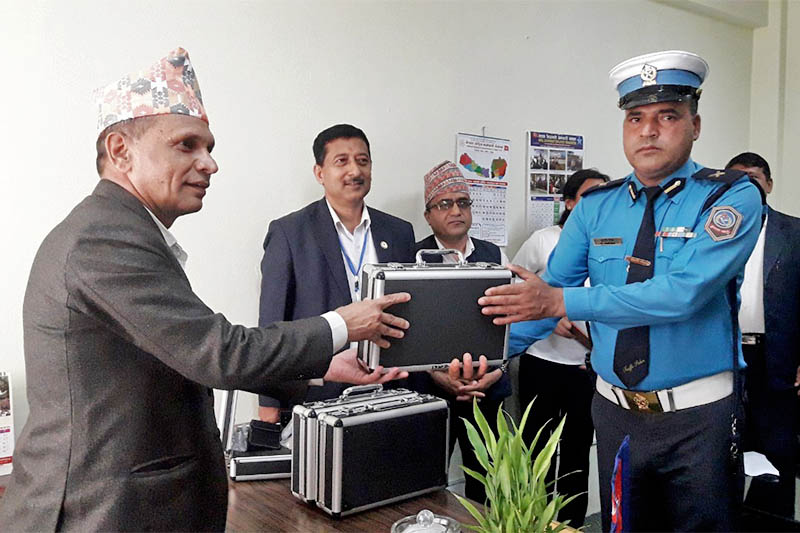 Minister for Internal Affairs and Law of Province 4, Hari Bahadur Chuman, hands over a breathalyzer machine to a traffic police personnel, in Pokhara, on Tuesday, April 16, 2019. Photo: Bharat Koirala/THT
