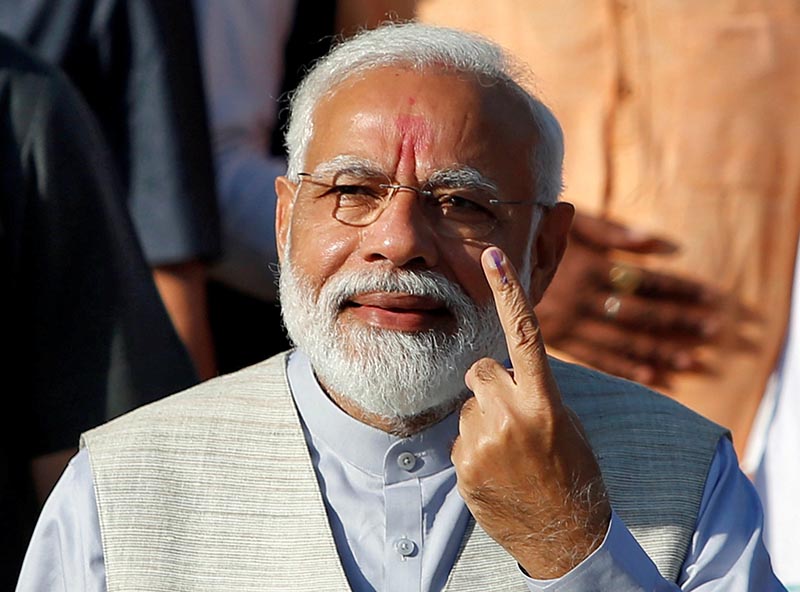 India's Prime Minister Narendra Modi shows his ink-marked finger after casting his vote outside a polling station during the third phase of general election in Ahmedabad, India, April 23, 2019. REUTERS/Amit Dave