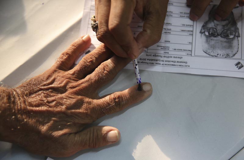An elderly Indian citizen gets ink mark on his finger prior to voting at a polling center during the fourth phase of general elections in Mumbai, India, Monday, April 29, 2019. Photo: AP