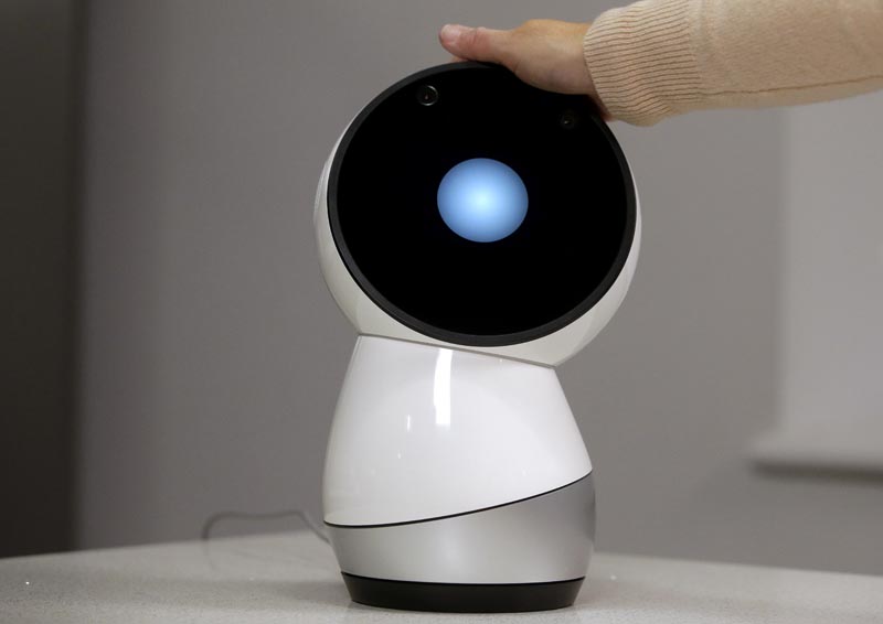 FILE: In this November 21, 2017, file photo Massachusetts Institute of Technology professor and robotics researcher Cynthia Breazeal reaches to touch social robot Jibo at the company's headquarters in Boston. Photo: AP/file
