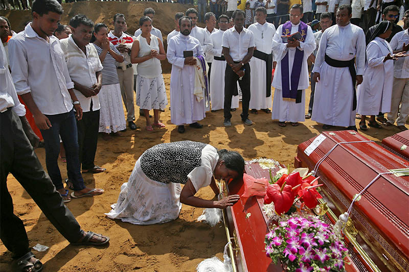 A woman reacts next to a coffin during a mass burial of victims, two days after a string of suicide bomb attacks on churches and luxury hotels across the island on Easter Sunday, at a cemetery near St. Sebastian Church in Negombo, Sri Lanka April 23, 2019. Photo: Reuters