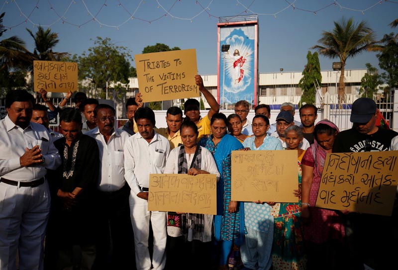 People hold placards as they pray for the victims of Sri Lanka's serial bomb blast, outside a church in Ahmedabad, India, April 21, 2019. Photo: Reuters
