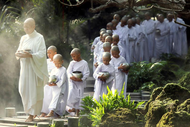 A Buddhist nun walks in line with novice nuns to receive food from people during the Songkran Festival at the Sathira-Dhammasathan Buddhist meditation centre in Bangkok, Thailand, April 14, 2019. Photo: Reuters