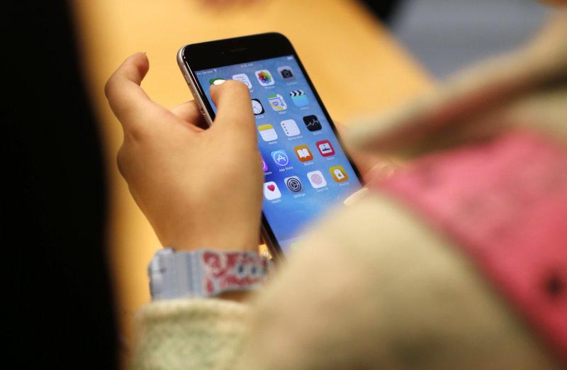 FILE - In this Sept. 25, 2015, file photo, a child holds an Apple iPhone 6S at an Apple store on Chicago's Magnificent Mile in Chicago. Photo: AP